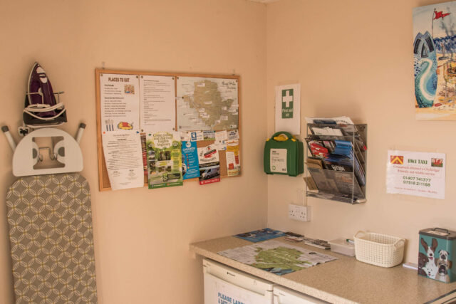 An ironing board and iron placed against a wall